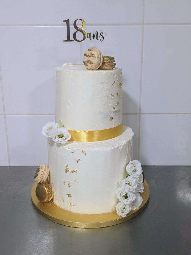 Cake design pour anniversaire 18 ans, blanc et doré avec des fleurs blanches et macarons dorés