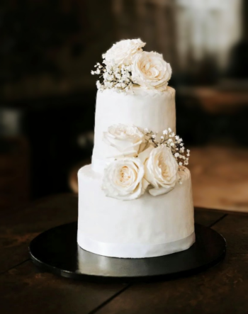 Wedding cake noir et blanc sur deux étages, décoré avec des fleurs