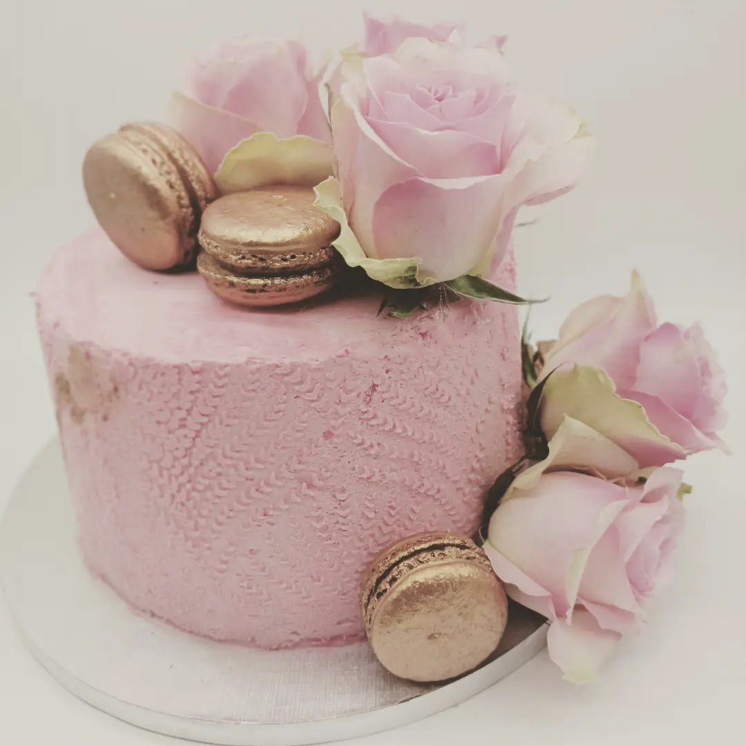 Wedding cake rose et dorés, recouvert de macarons et de roses roses